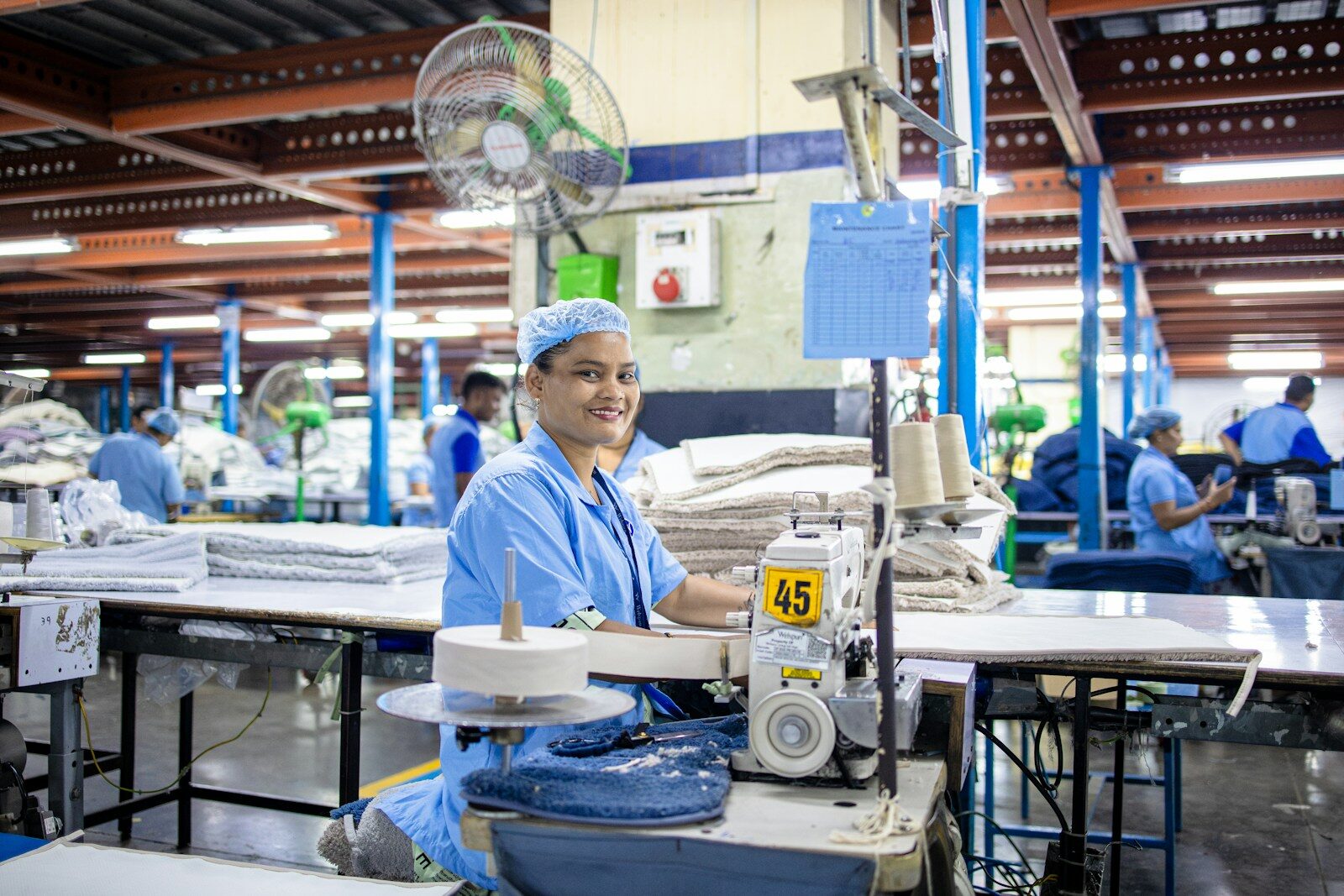 Worker sewing fabric in a textile factory